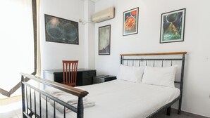 A neatly arranged bedroom with a bed, a chair, a desk, and a nightstand. - Koridalos Terrace Apt w Spectacular View (Korydallos)
