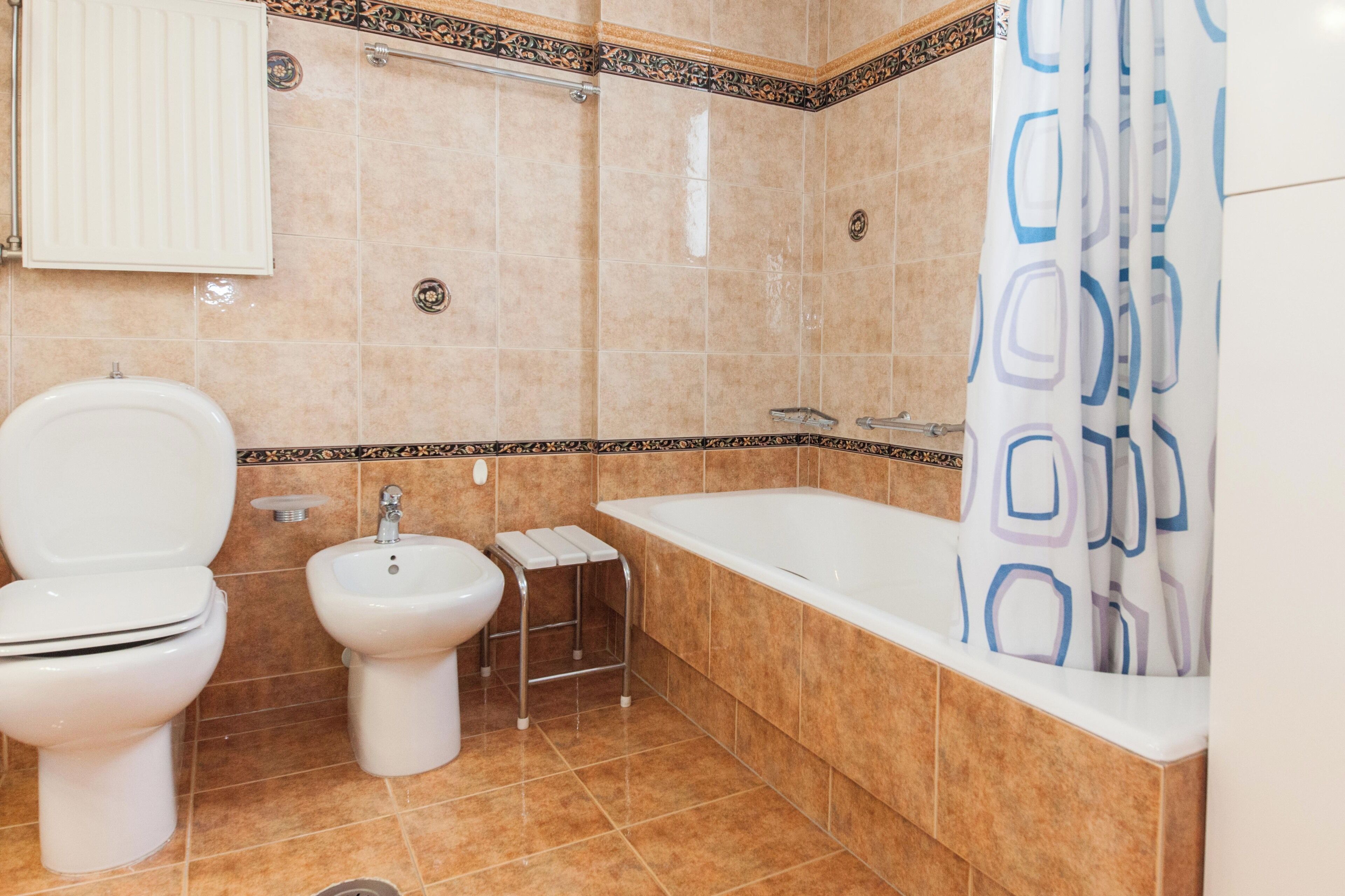 A bathroom with a toilet, bidet, and bathtub.