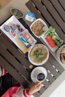 A table with various food items, including a plate of food, a cup of coffee, and condiments.