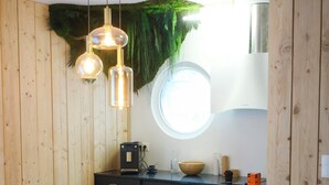 Una cocina moderna con paneles de madera, una mesa redonda para comer y lámparas colgantes.