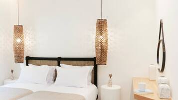 A modern bedroom with a bed, two hanging lamps, a bedside table with a cup, and a small stool.