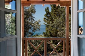 Une pergola en bois offrant une vue sur la mer et les arbres.