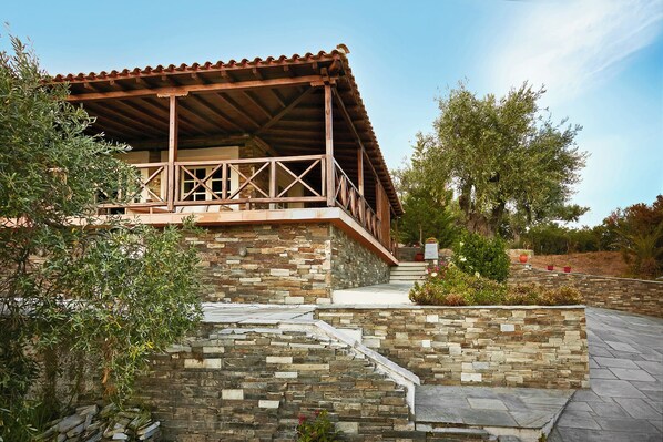 Un bâtiment en pierre doté d’un balcon en bois et d’un escalier en pierre menant à l’entrée.