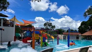 A water park with a pool, slides, and play structures. - Los Lirios Hotel  (El Coco)