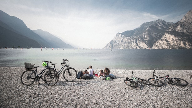 Une plage de galets avec des vélos et des gens.