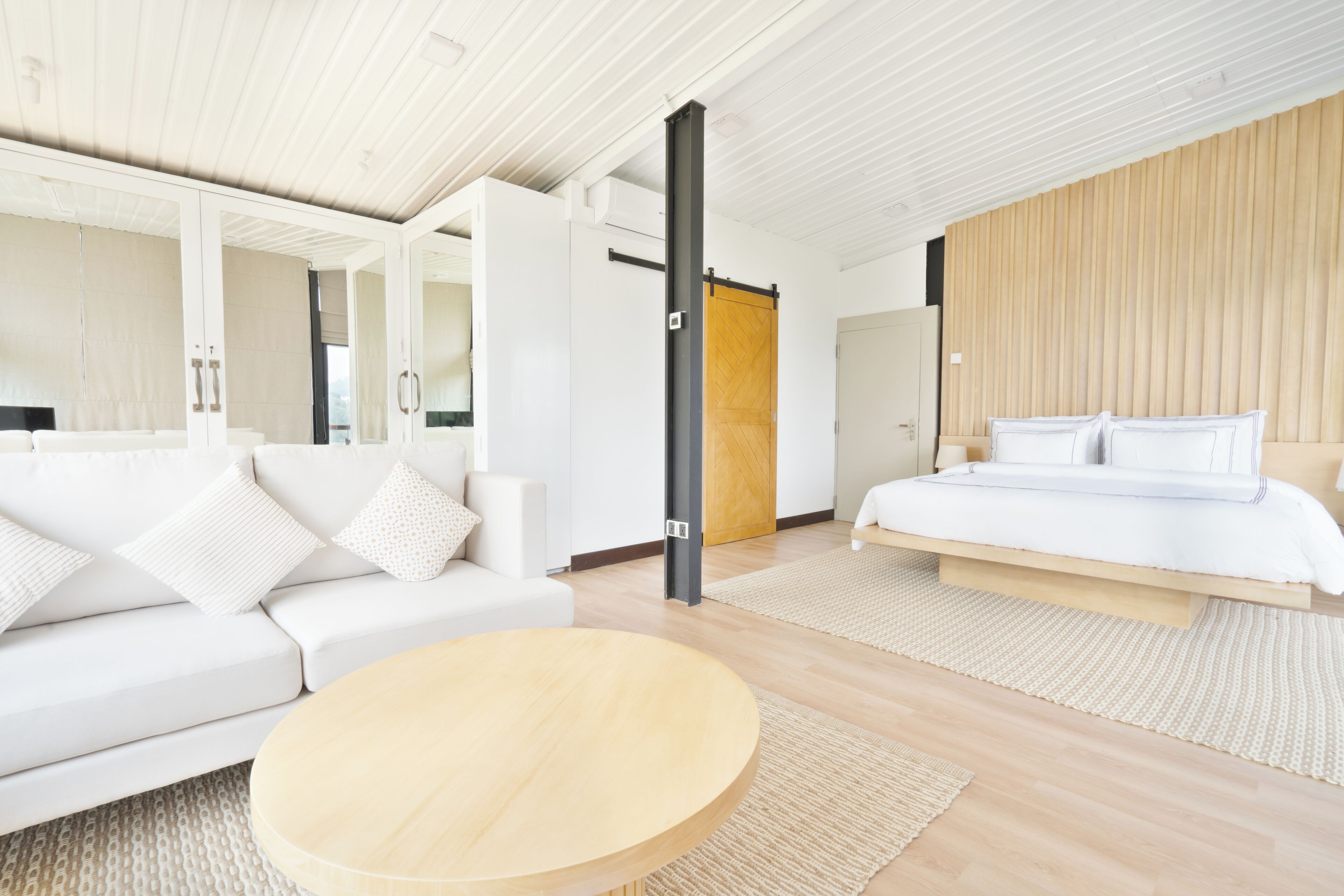 A modern bedroom with a bed, a sofa, and a coffee table.
