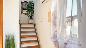 A staircase with wooden steps, a potted plant, a hanging macrame decoration, and a window with a sheer curtain. - House Rea is ideal for a retreat in nature, close to the richness of Istria ! (buzet)