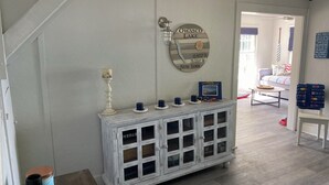 Una habitación con un armario blanco, un reloj de pared y un cuadro enmarcado.