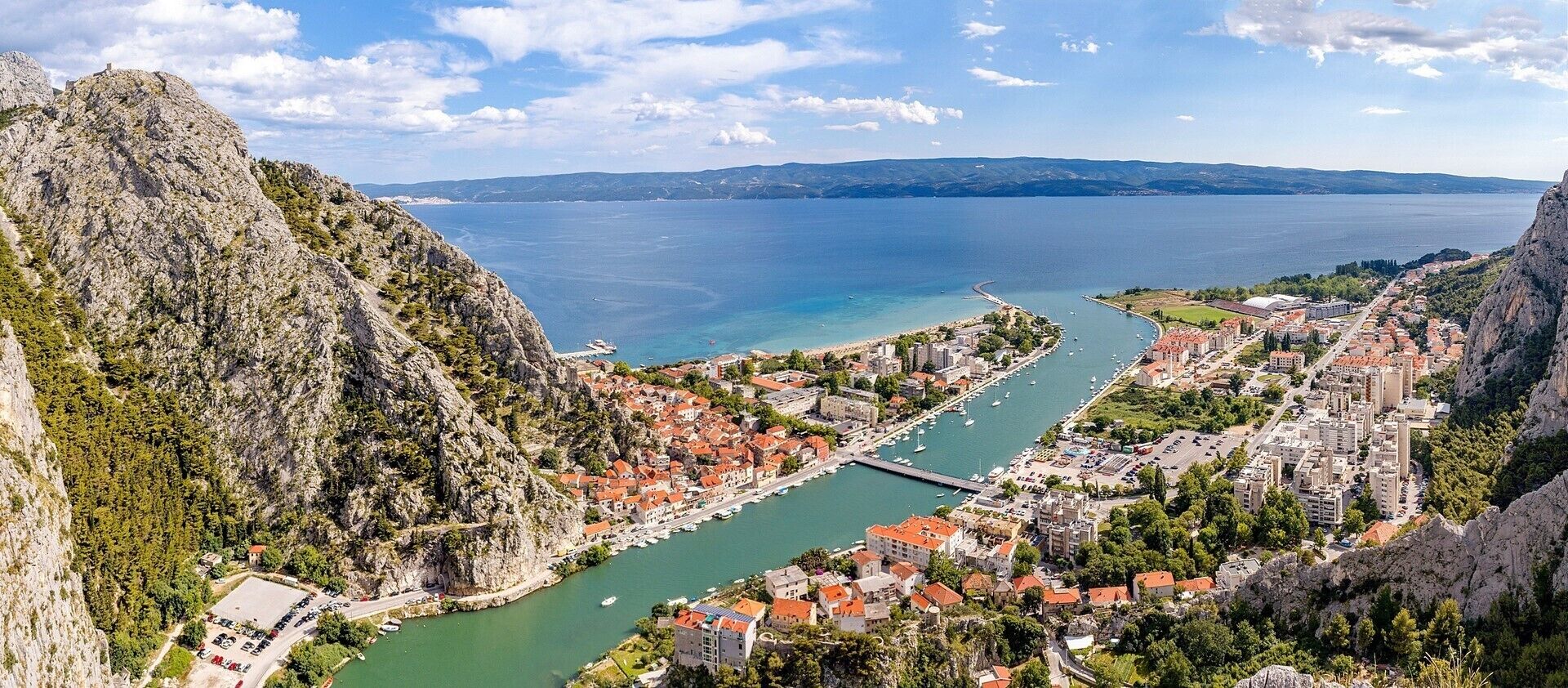Une ville côtière dotée d’un port de plaisance, de falaises rocheuses et offrant une vue dégagée sur la mer.