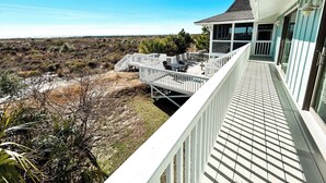 Een balkon met uitzicht op een strand en duinen.