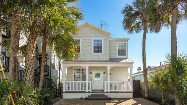 A two-story house with a front porch, surrounded by palm trees and a brick driveway. - Southern Charmer|Private Backyard|Walk to Downtown (Saint Augustine)