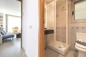 A bathroom with a shower, toilet, and sink.