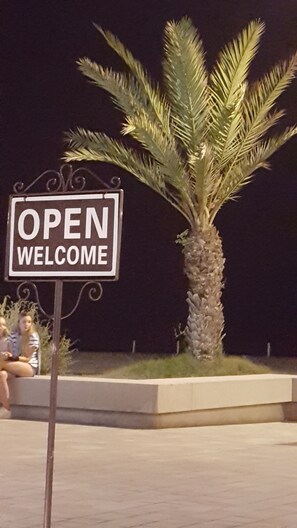 A 'OPEN WELCOME' sign with a palm tree in the background. - A luxury apartment in the center of Calafell (Calafell)