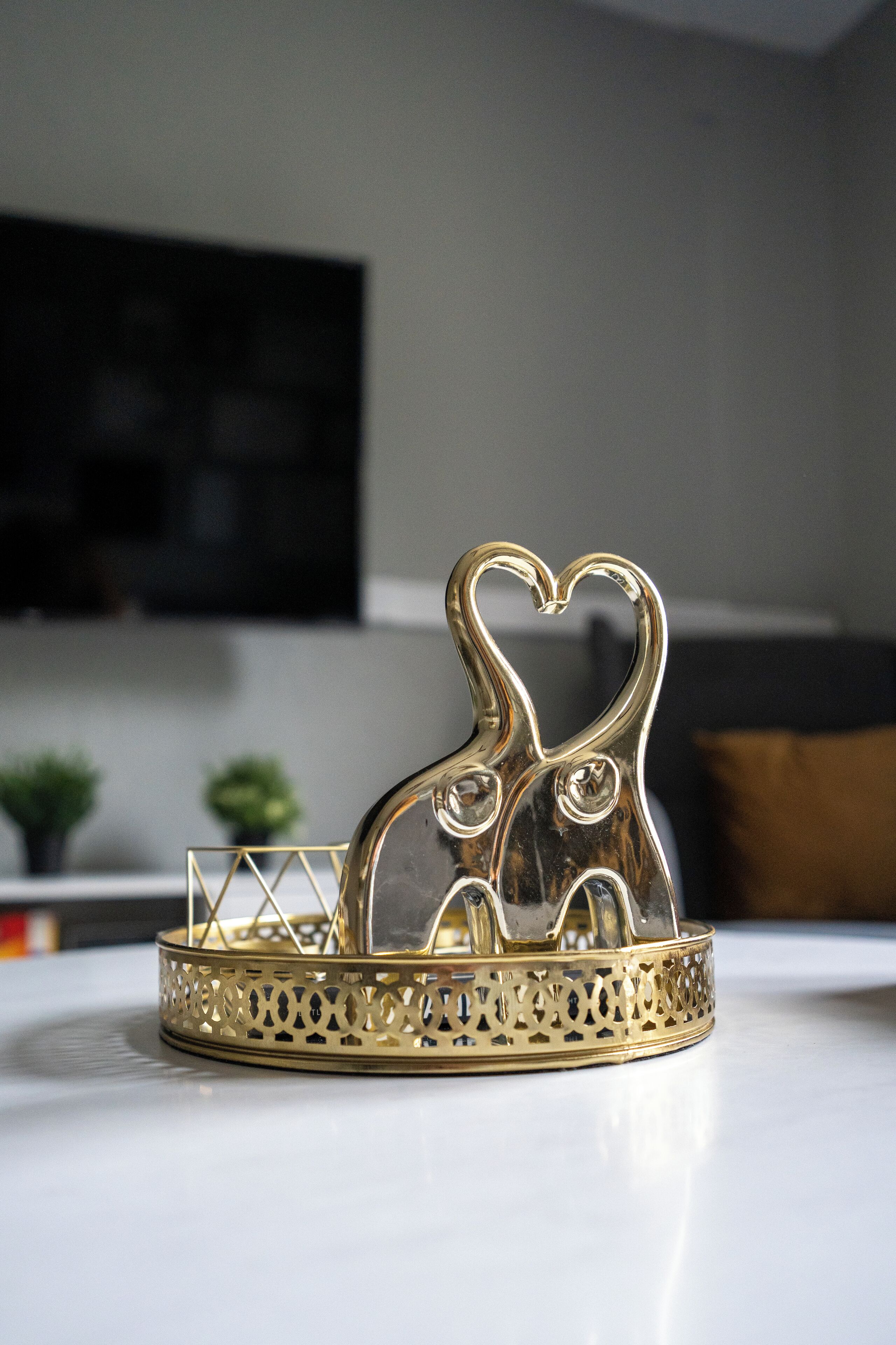 A decorative tray with a heart-shaped elephant design, placed on a white surface in a room with a modern aesthetic.
