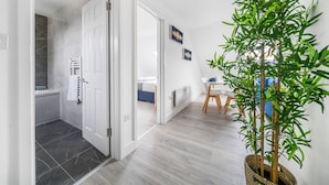Ett modernt hotellrum med badrum, matplats och sällskapsrum.