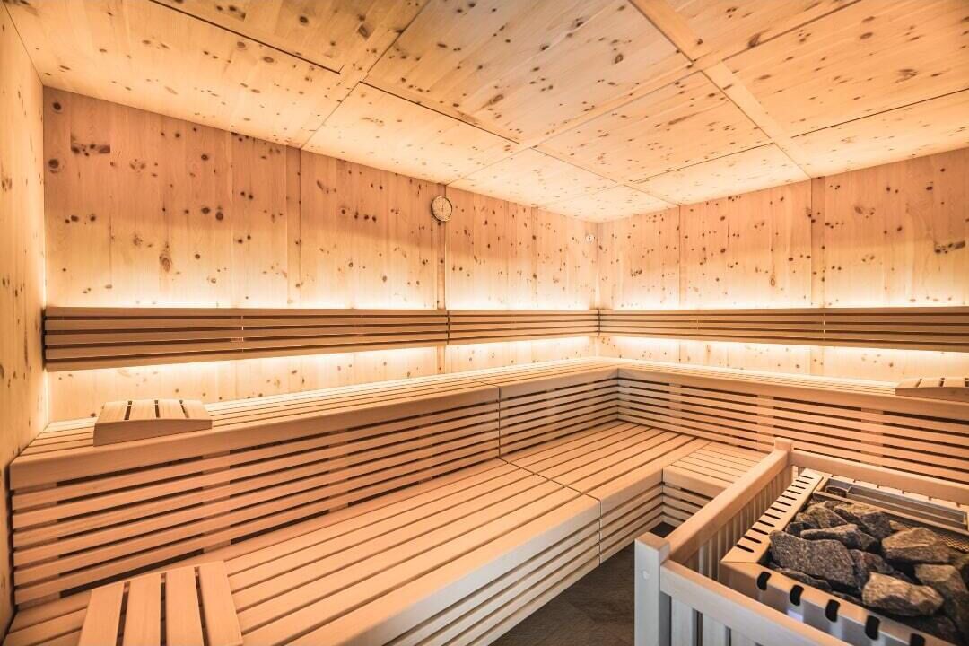 Una sauna con bancos de madera y una piedra para lavarse.