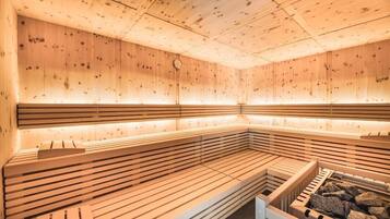 Una sauna con bancos de madera y una piedra para lavarse.