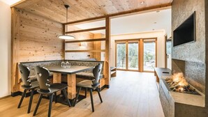 Un comedor moderno con techo de madera, chimenea de piedra y vistas al exterior.