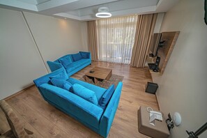 Apartamento luxo, vista para a cidade | Área de estar | Smart TV 64 polegadas com canais digitais