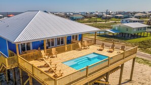 Un muelle de madera con piscina, rodeado de casas de playa.