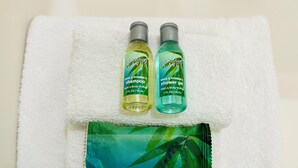 Two bottles of rainkissed leaves shampoo and shower gel, and a packet of moisturizing bath soap, all placed on a white towel. - 2 Queens - 3 Miles to Cedar Point! (Sandusky)
