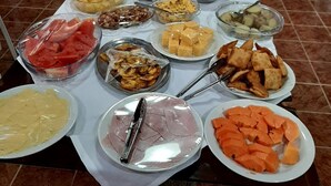 Una mesa de buffet con diversos alimentos, como frutas, verduras y platos ya preparados.