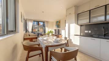 Habitación triple Deluxe, 3 habitaciones, vista a la ciudad | Área de sala de estar | Piso con calefacción
