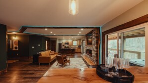 A spacious living area with a wooden coffee table, a sofa, and a fireplace.