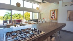 Uma cozinha moderna com uma ilha grande, fogão a gás e um espaço de refeições com mesa e cadeiras.