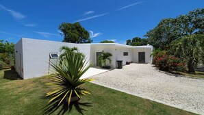 A modern house with a white exterior, a gravel driveway, and a well-maintained lawn.