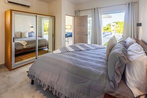 A bedroom with a large bed, a sliding door closet, and a view of a swimming pool.