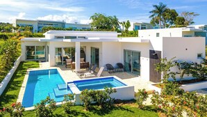 A modern house with a swimming pool, large glass doors, and a well-maintained garden.