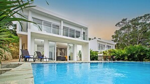 Une maison moderne à deux étages avec une piscine.