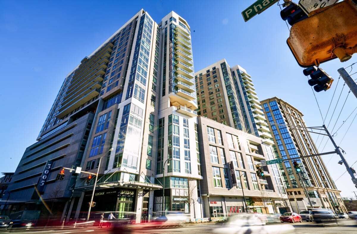 A high-rise building with multiple floors, large windows, and a prominent entrance.