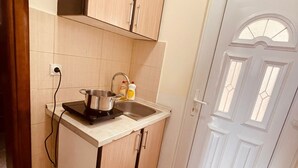 A compact kitchen with a sink, stove, and cabinets. - Mahara Doo (Bar)