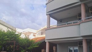 A multi-story building with a stone wall and a gated entrance. - Mahara Doo (Bar)