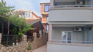 A narrow street with stone walls and a small garden with a potted plant. - Mahara Doo (Bar)