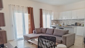 Un appartement moderne comprenant un espace de vie, une kitchenette et un coin repas.