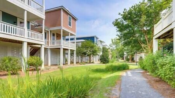A residential area with a pathway, houses with balconies, and greenery. - Pass Christian Vacation Rental < 1/2 Mi to Beach! (Pass Christian)