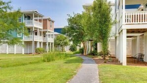 A residential area with two-story houses, a paved pathway, and a white fence. - Pass Christian Vacation Rental < 1/2 Mi to Beach! (Pass Christian)