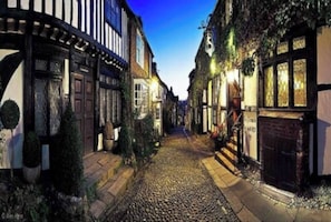 A narrow cobblestone street lined with traditional half-timbered buildings, suggesting a historic European town. - Whytecroft -Fabulous Family Fun! - Pass the Keys (Camber)