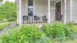 A porch with four black chairs, a table, and string lights. - Family Home w/ Yard & Fire Pit in Middleburgh! (Middleburgh)