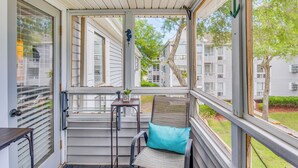 A covered porch with a chair and table, overlooking a residential area. - 1 Block to Beach: Myrtle Beach Condo w/ Pool! (Myrtle Beach)