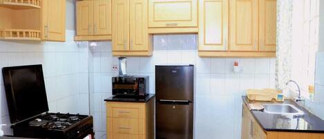 Appartement Deluxe, vue ville | Cuisine privée | Réfrigérateur, micro-ondes, batterie de cuisine, vaisselle et ustensiles
