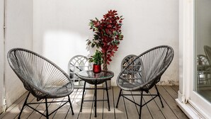 A small outdoor patio with two wicker chairs, a round table, and a potted plant. - Luxury 2 Bedrooms Flat Next to Harrods (London)