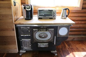 A vintage McClary Kootenay stove with a coffee maker and toaster on top.