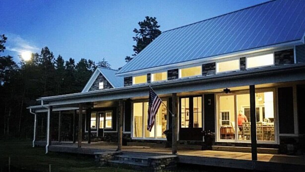 A two-story house with a covered porch and a large window overlooking a grassy area. - Red Dog Farms Modern Studio Apt (Rocky Point)