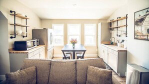 A compact kitchen with a dining table, built-in appliances, and a cozy seating area. - Red Dog Farms Modern Studio Apt (Rocky Point)
