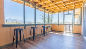 A spacious room with wooden flooring, large windows, and bar stools. - The heart of the desert with amazing views and hiking trails right outside! (Tucson)