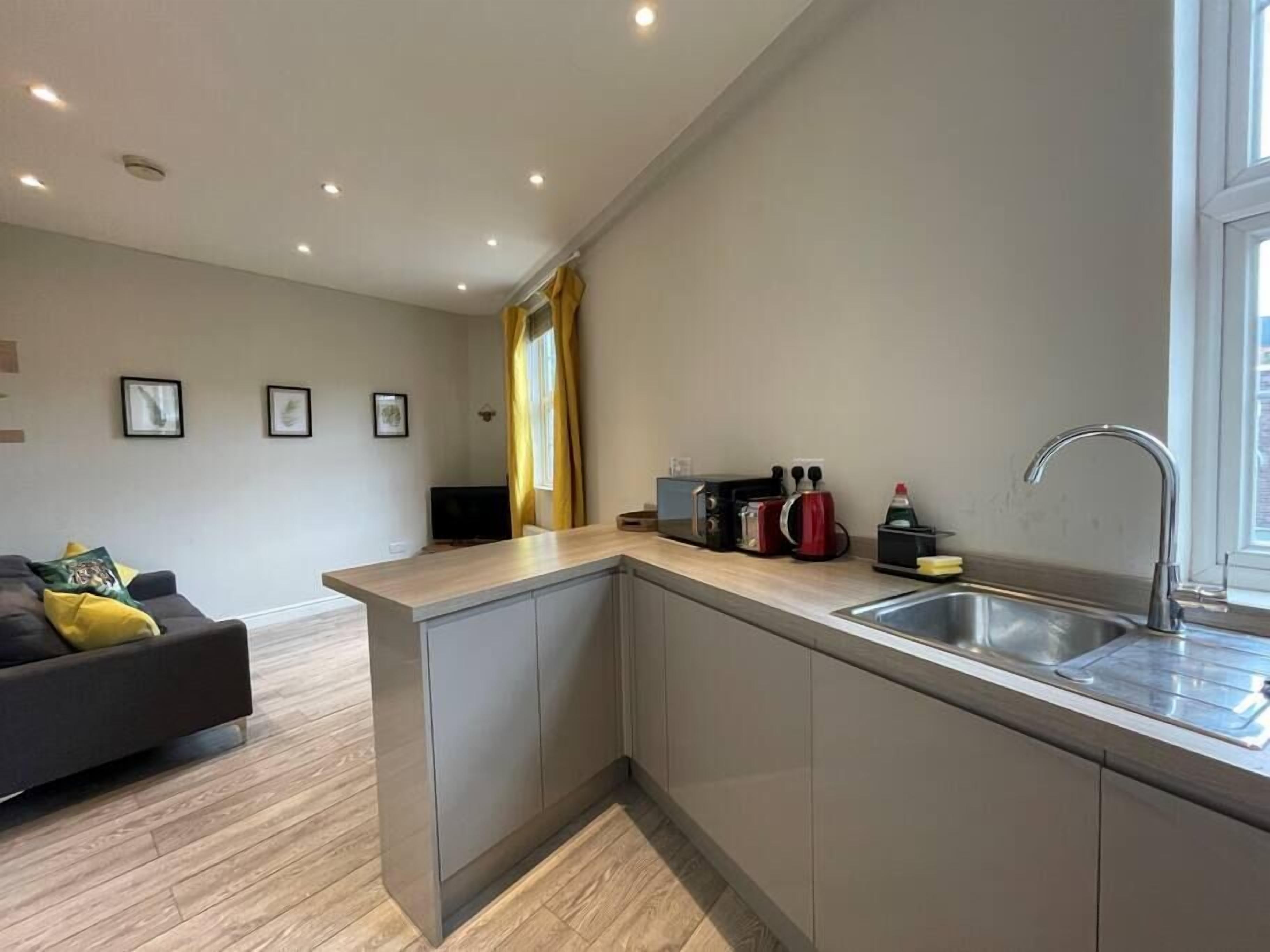 Een moderne keuken met een ingebouwd eiland, een spoelbak en een raam.